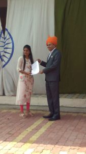 Nikitaben Bhagubhai receiving award for achievements. Works in Red cross